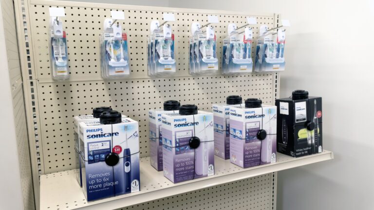 セキュリティ対策が施された箱に入った、電動歯ブラシや電気シェーバーなどの健康関連製品。